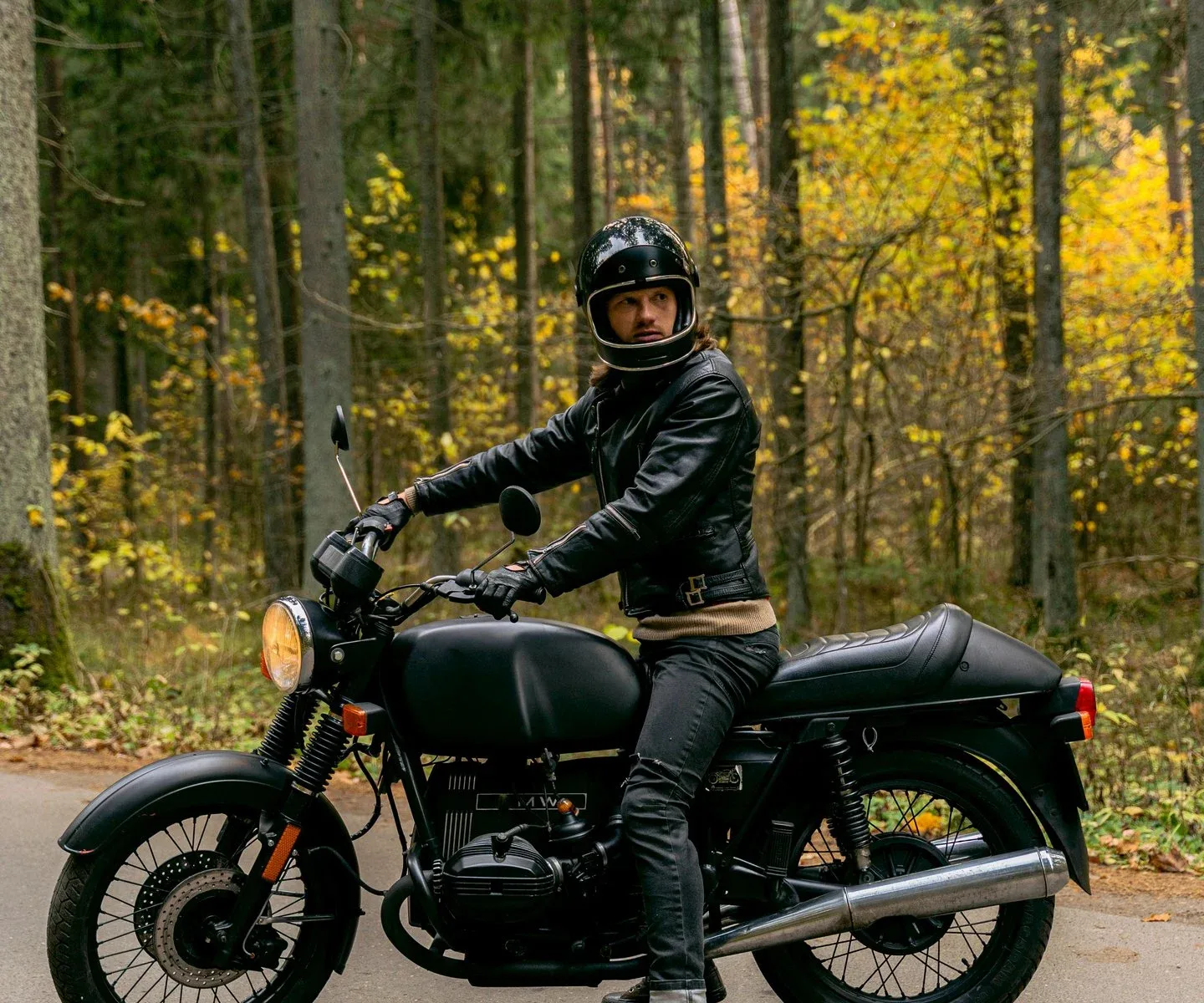 Biker on a cafe racer in leather jeans and jeans