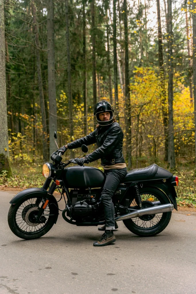 Biker on a cafe racer in leather jeans and jeans