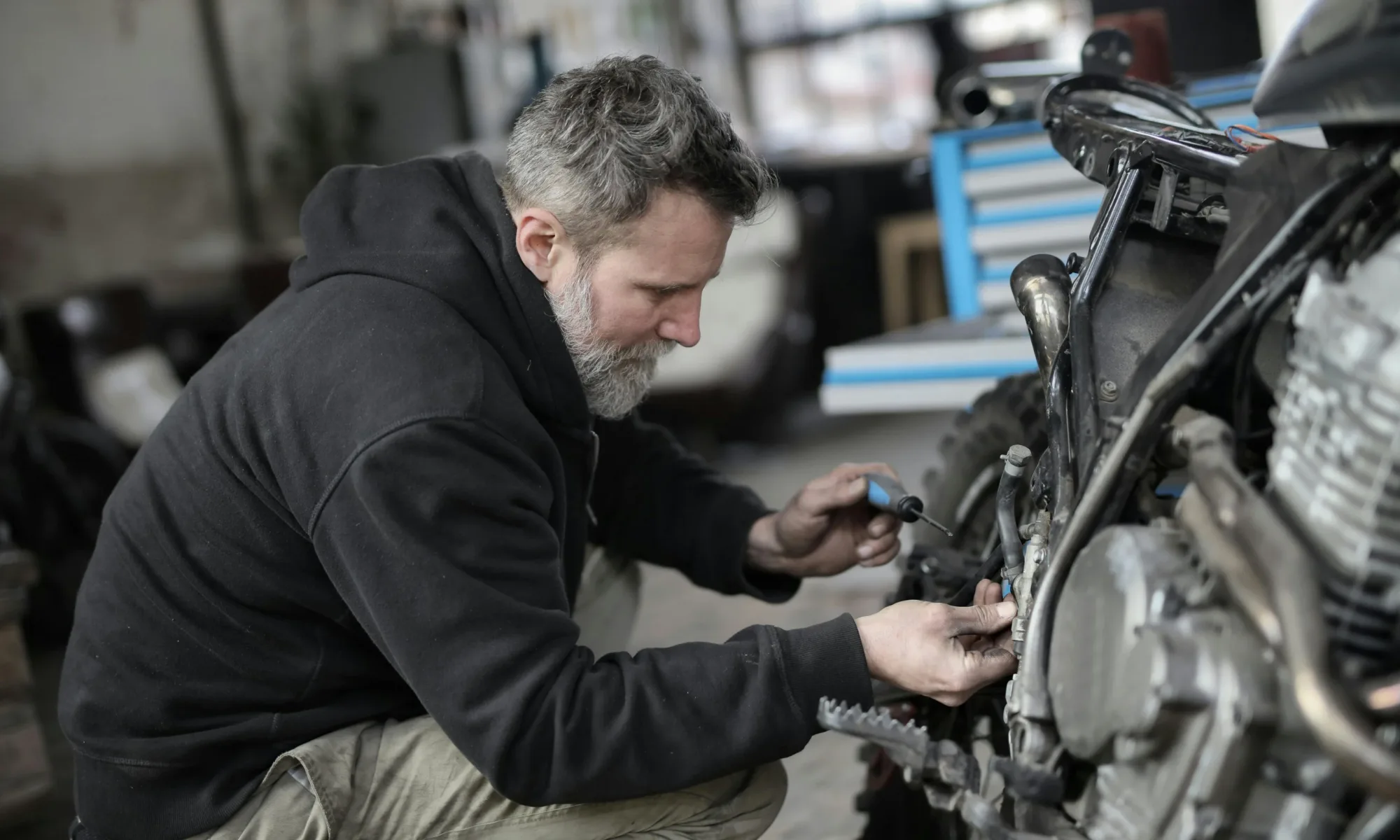 Best Motorcycling Accessories 2025 Man repairing a motorcycle