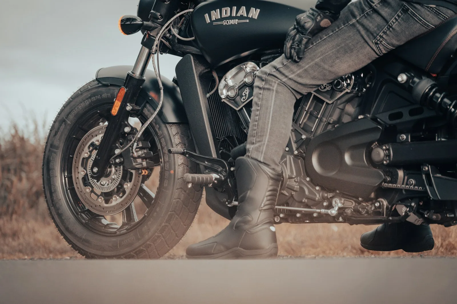 Motorcycle Riding Boots a man riding on the back of a motorcycle