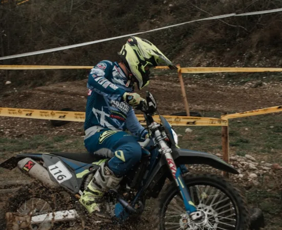 Motorcycle Riding Jeans Pants a person riding a dirt bike on a muddy track