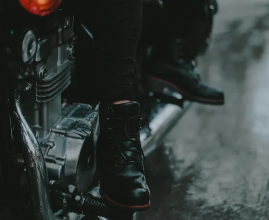 Motorcycle Riding Boots a man sitting on a motorcycle in the rain