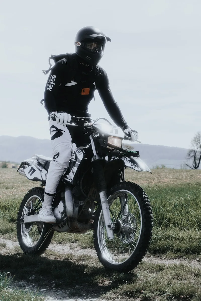 Motorcycle Riding Helmets black and white motorcycle on green grass field during daytime