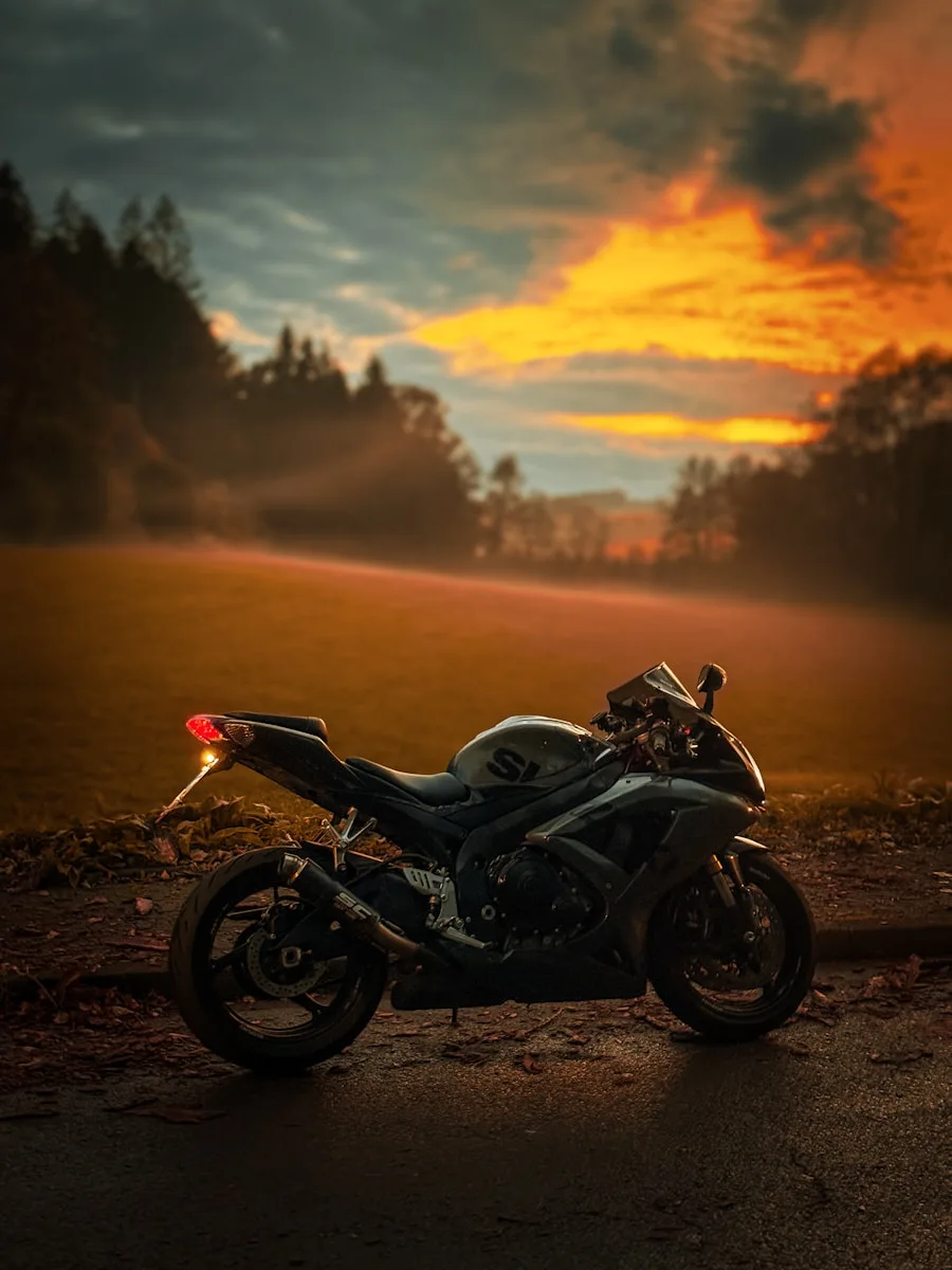 Motorcycle parked with an evening sunset in the background.