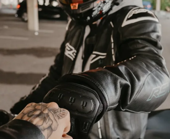 Motorcycle Riding Gloves Two motorcyclists bump fists in solidarity.