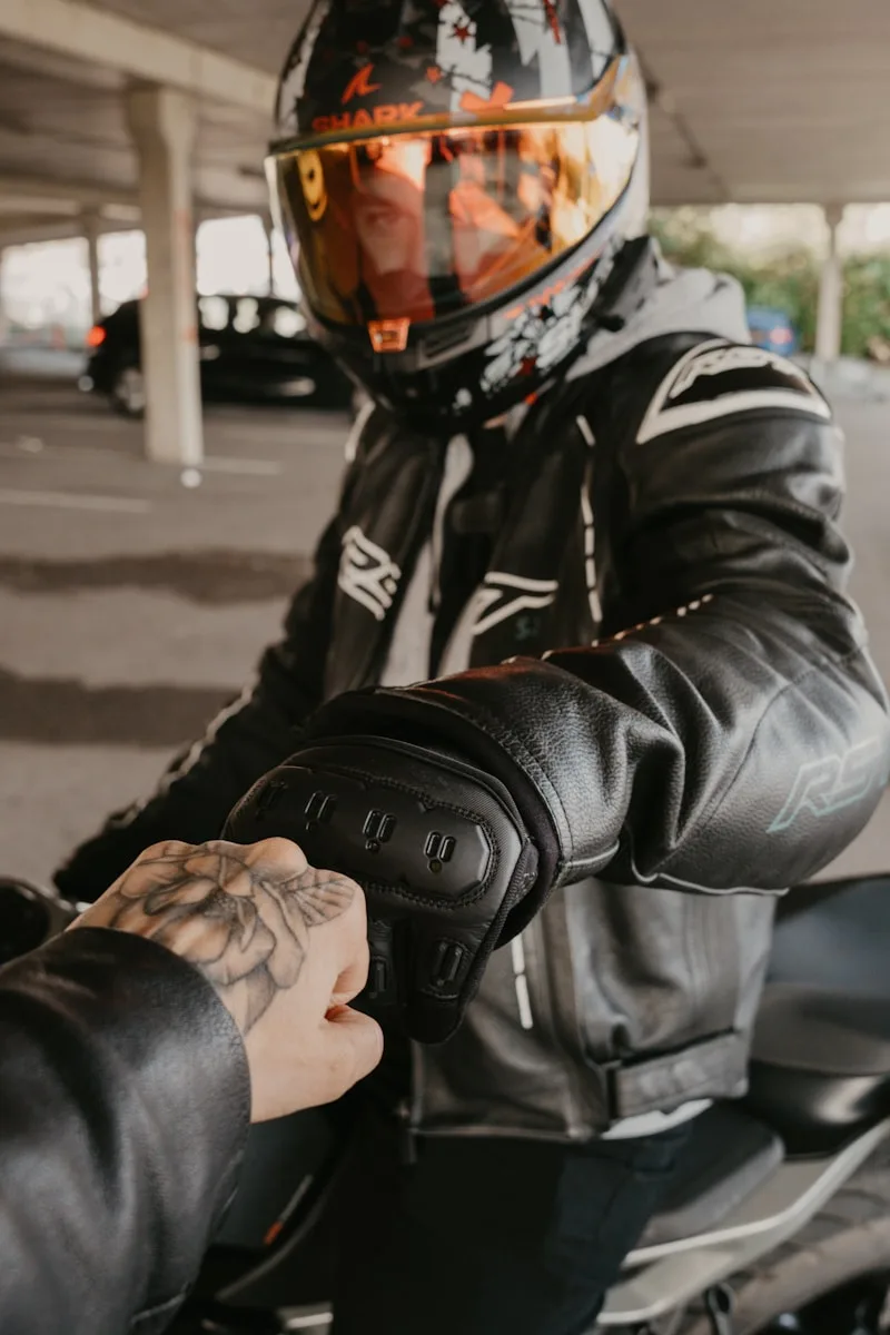 Motorcycling Blogs & Reviews Two motorcyclists bump fists in solidarity.